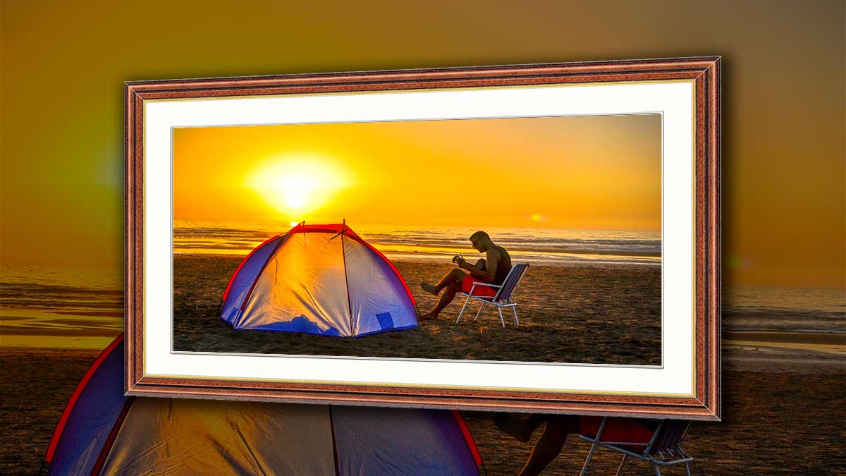 Framed poster of a male camping on a beach in the sunset