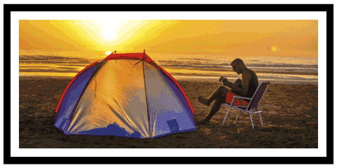 Photo of a man playing a guitar on the beach in a basic matte black frame